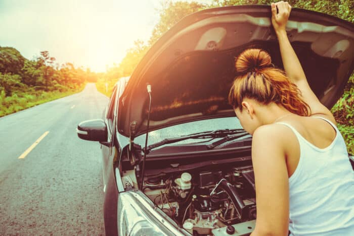 sinistre auto - femme ouvre le capot de la voiture