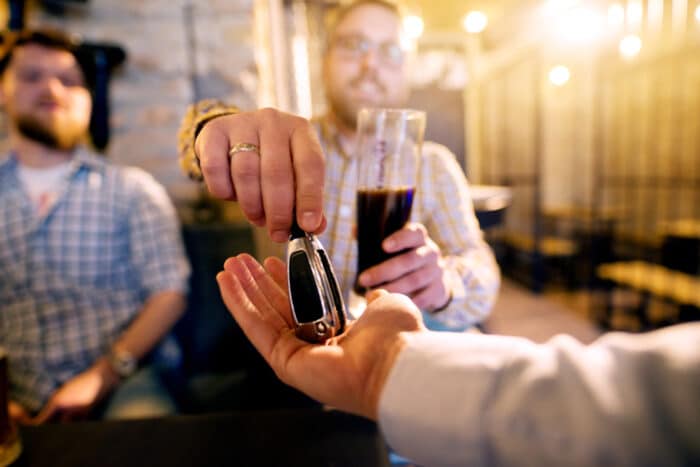 homme ivre qui tend ses clés de voiture